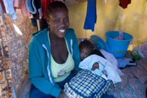 2010 Evelyn Hockstein/CARE) *Emy Mercie, 39, was holding her newborn baby in the hospital soon after delivery when she felt the earth start to share on Jan 12. She received a hygiene kit (background) from CARE.